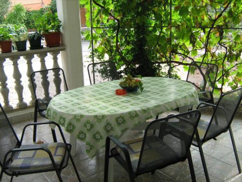 a table with a green table cloth on a patio at Jarmila in Rogoznica