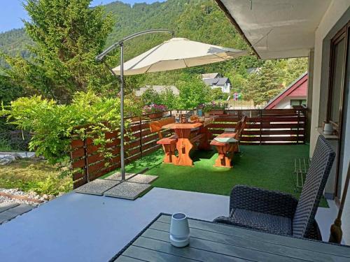 a patio with a table and chairs and an umbrella at Apartment Magnolia in Blejska Dobrava
