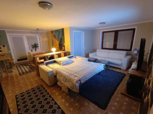 a bedroom with a bed and a couch in it at Apartment Magnolia in Blejska Dobrava