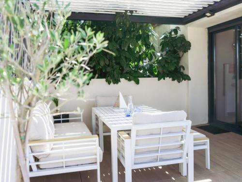 a white table and chairs on a patio at 36 2 l air marin Penthouse Netflix Clim Free park Navette Grands Buffets Accès direct autoroute et plages in Narbonne