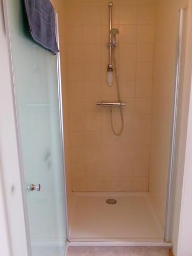 ein Badezimmer mit Dusche mit Glastür in der Unterkunft b&b Kraaiberg in Heuvelland
