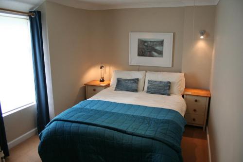 a bedroom with a bed with two pillows on it at Stylish 4Bed Cottage with parking near town and beach in Lyme Regis