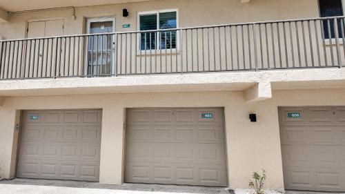 a house with two garage doors and a balcony at Sanibel Siesta on the Beach in Sanibel