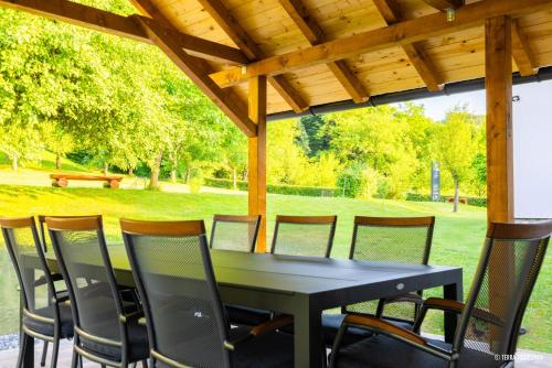 a black table and chairs under a wooden roof at Ranch Zeru 