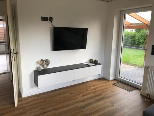 a living room with a flat screen tv on a wall at Moin Urlaub! Am alten Hafen in Friedrichskoog