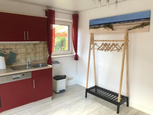 a kitchen with a shelf in the corner of a room at Moin Urlaub! Am alten Hafen in Friedrichskoog