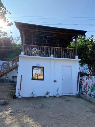 a small white building with a roof and a door at Philipp's Beachfront Cabin - Calatagan in Calatagan
