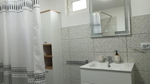 a white bathroom with a sink and a mirror at Casa EDI in Ferihaza