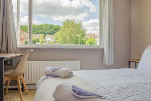 a bedroom with a bed and a desk and a window at 4 Bed House Perfect for Contractors - Families and Relocation in Stoughton