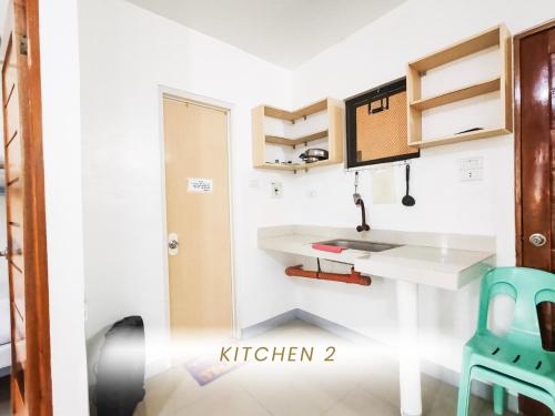 a kitchen with a white counter and a blue chair at DCAR Residences - Transient House in Tanza