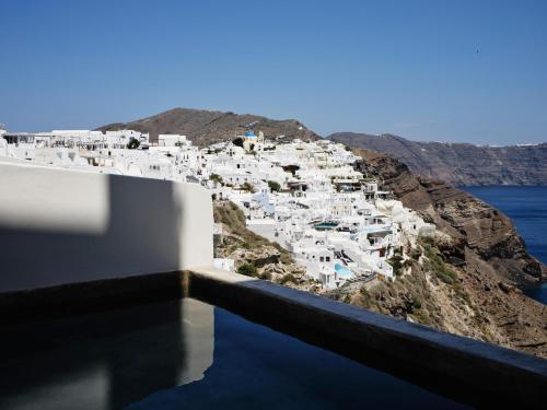 a view of a town on a hill with white buildings at Andronis Luxury Suites in Oia