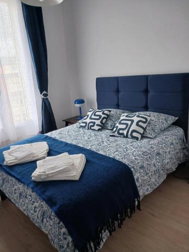 a bedroom with a blue bed with towels on it at Le Grand Bleu in Saint-Valéry-en-Caux
