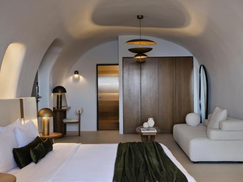 a bedroom with a white bed and a couch at Andronis Luxury Suites in Oia