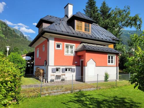 a house with a black roof at Villa Schnuck - das rote Ferienhaus in Bad Gastein