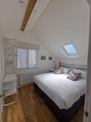 Un dormitorio con una cama grande y una ventana. en Blue Hills Luxury Apartment, Bay Front with Parking, en Falmouth
