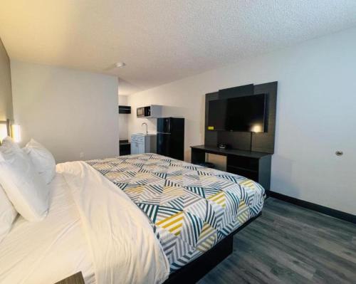 a bedroom with a bed and a flat screen tv at Studio 6 Southgate MI Detroit in Southgate
