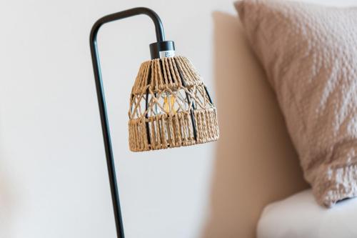 a lamp on a wall next to a pillow at BnB Feuille de Vigne in Saint-Léonard