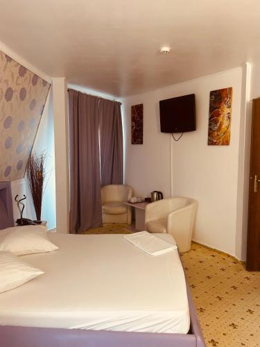 a hotel room with a bed and a tv at Hotel Zava Civic Center in Bucharest