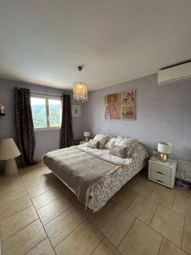 une chambre avec un lit et un lustre dans l'établissement Villa -Vue panoramique splendide -Piscine privée, à Auribeau-sur-Siagne