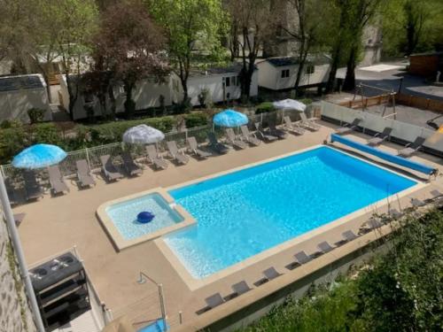 an overhead view of a swimming pool with chairs and umbrellas at Les Rives d’Auzon Mobil-home 6 pers in Lavilledieu