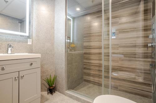 a bathroom with a shower with a toilet and a sink at Olympia Hotel by Lodgo in Montréal