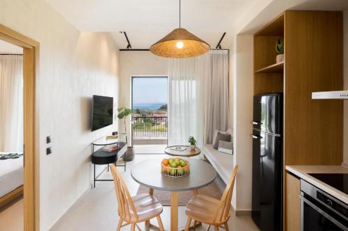 a small kitchen and dining room with a table and chairs at Pnoes Luxury Suites in Paliouri