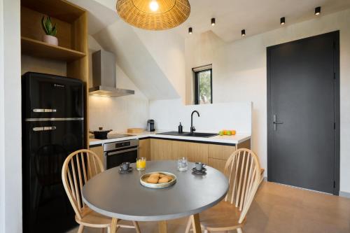 a kitchen with a table and chairs and a sink at Pnoes Luxury Suites in Paliouri