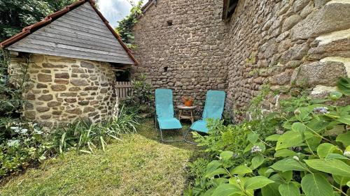 two blue chairs and a table in a garden at Gîte Gîte du Chatelard 87 N°2 in Jabreilles-les-Bordes
