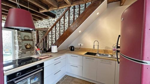 a kitchen with white cabinets and a red refrigerator at Gîte Gîte du Chatelard 87 N°2 in Jabreilles-les-Bordes