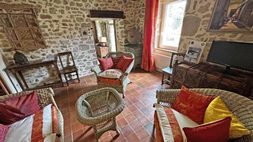 a living room with wicker chairs and a tv at Gîte Gîte du Chatelard 87 N°2 in Jabreilles-les-Bordes