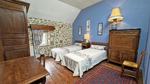 a bedroom with two beds and a table and a dresser at Gîte Gîte du Chatelard 87 N°2 in Jabreilles-les-Bordes
