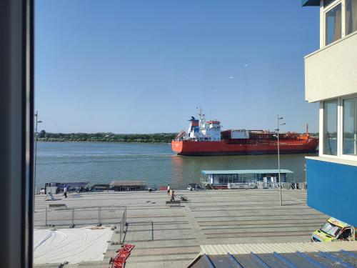 a large red ship is docked at a dock at Apartament Pelicanul in Tulcea