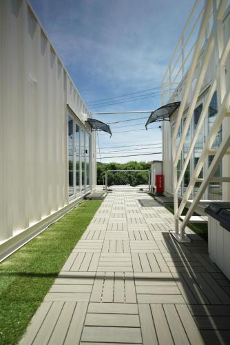 an empty walkway between two buildings with grass at 最大18名OK 南城市 百名の大型貸別荘 BBQ ビーチ近くでグループ滞在に最適 Seaside House Ichika in Nanjo