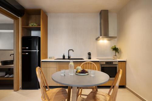 a kitchen with a table with a bowl of fruit on it at Pnoes Luxury Suites in Paliouri