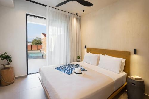 a bedroom with a large bed with a large window at Pnoes Luxury Suites in Paliouri