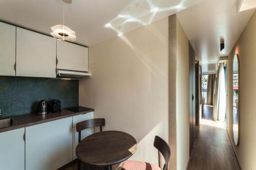 une petite cuisine avec une table et des chaises en bois dans l'établissement L'Escale Royale La Ferté-sous-Jouarre Marne Meaux, à La Ferté-sous-Jouarre