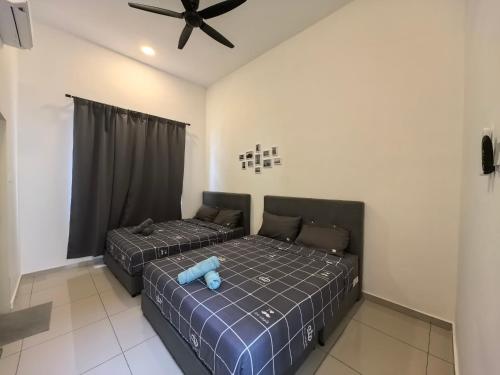 a bedroom with two beds and a ceiling fan at Padang Serai Wangi Roomstay 95 in Padang Serai