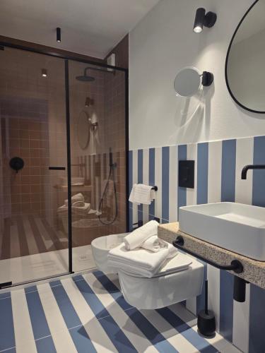 une salle de bain avec toilettes, lavabo et douche dans l'établissement Valesmeralda Boutique Rooms, Porto Cervo Marina, à Porto Cervo