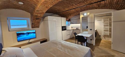 a bedroom with a bed and a desk and a kitchen at AppPrusnik in Ljubljana