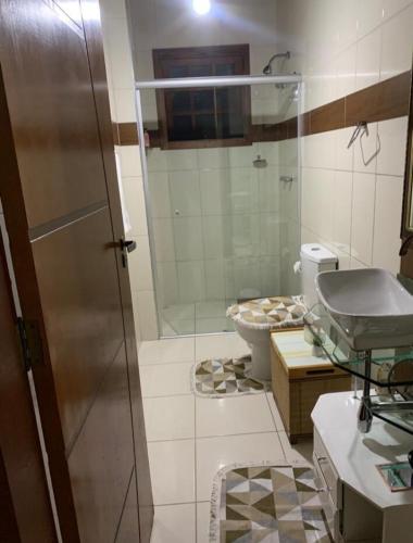 a bathroom with a glass shower and a toilet at 3 Pinheiros in Campos do Jordão