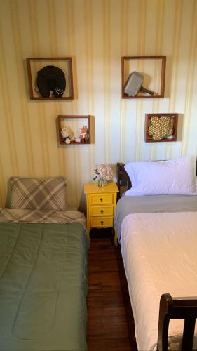 a bedroom with two beds and a table and a chair at 3 Pinheiros in Campos do Jordão
