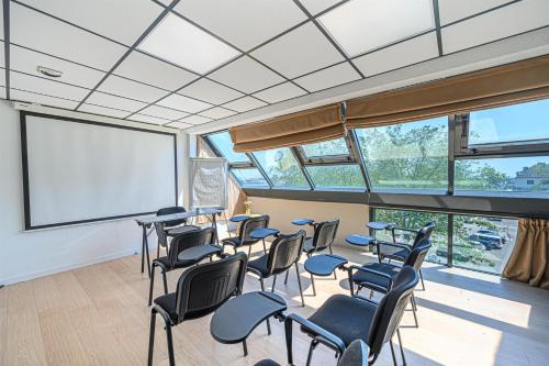 a classroom with chairs and a whiteboard in a room at Best Western Plus Hôtel Vannes Centre Ville in Vannes