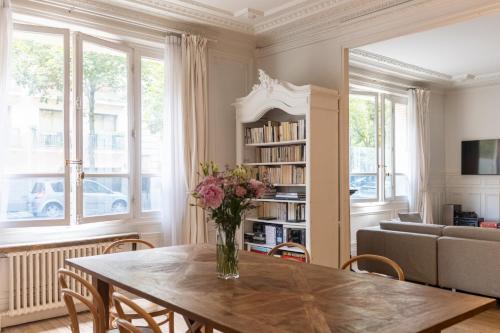 un salon avec une table avec un vase de fleurs dans l'établissement Luxurious 4 Bedroom Apartment next to The Eiffel Tower, à Paris