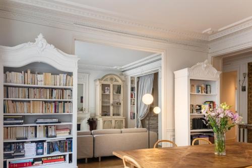 - un salon avec une table et des étagères dans l'établissement Luxurious 4 Bedroom Apartment next to The Eiffel Tower, à Paris