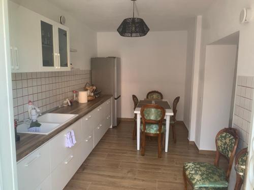 a kitchen with a sink and a table with chairs at Vintage Villa in Shkodër
