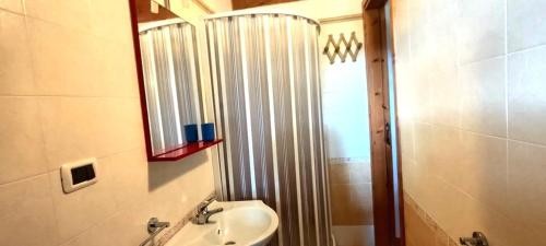a bathroom with a shower and a sink and a mirror at Solea Village sul mare in San Sostene Marina