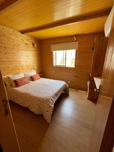 a bedroom with a bed in a wooden room at Casa da Praia in Carvalhal