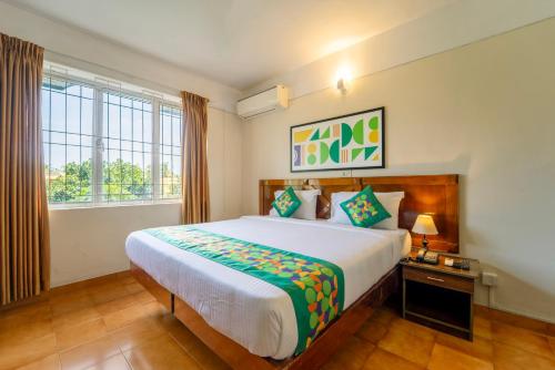 ein Schlafzimmer mit großem Bett und Fenster in der Unterkunft Treebo Classic Highway Side in Thiruvananthapuram
