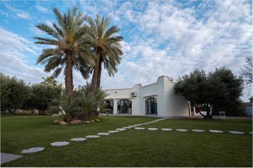 a white building with a palm tree in front of it at Villa Daïs - Marrakech in Marrakech