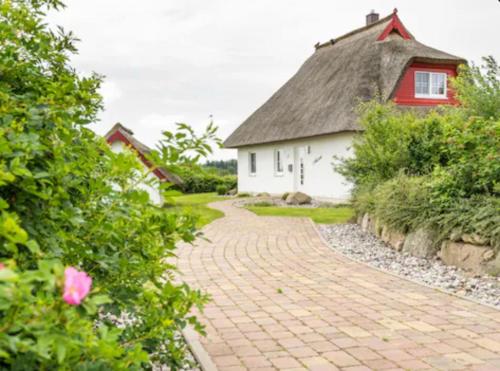 un sentiero di mattoni che conduce a una casa con il tetto di paglia di Krügers Auszeit a Zinnowitz